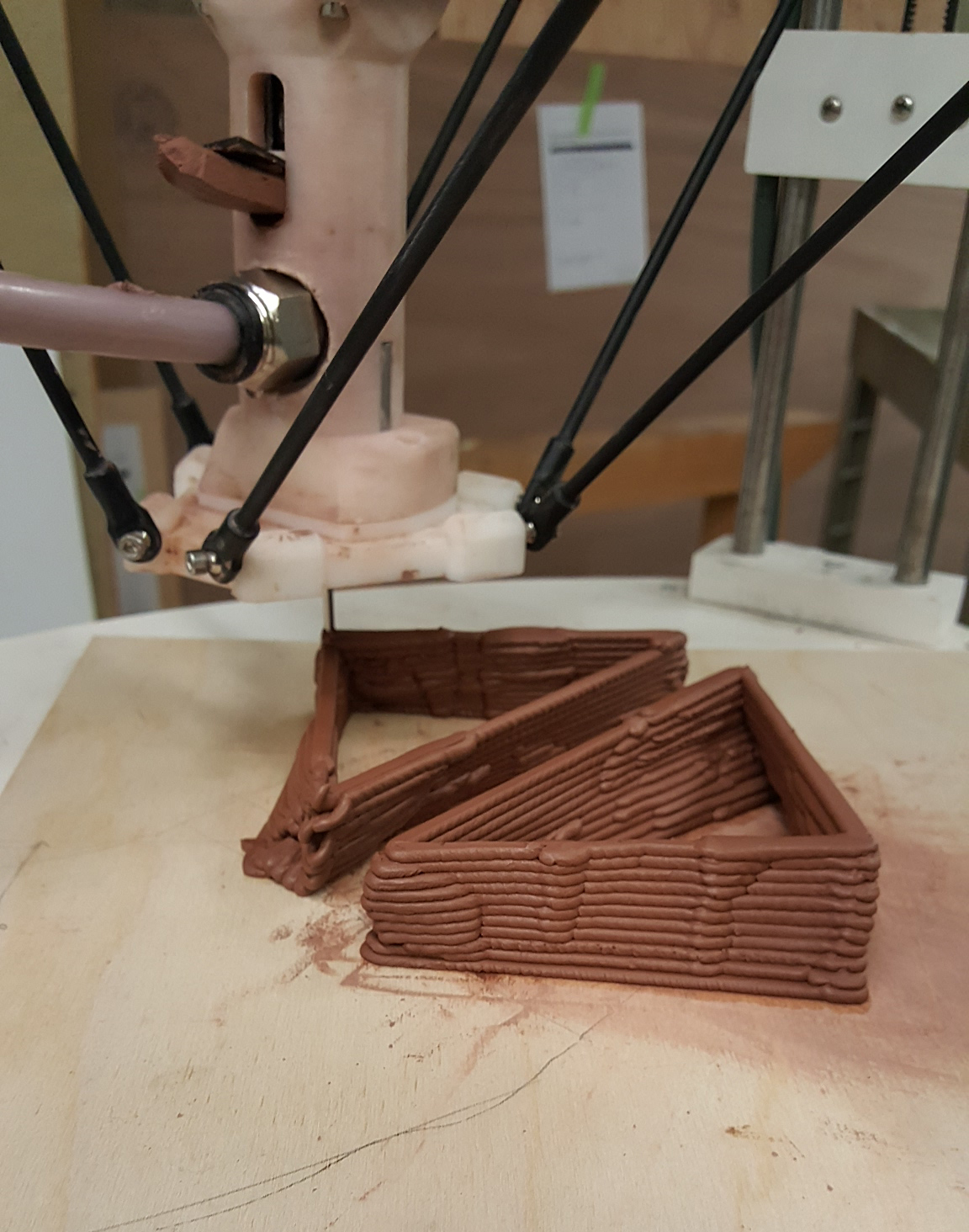 Robotic arm printing a triangular tray